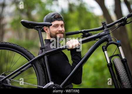 Männliche biker Fahrrad im Wald an einem sonnigen Tag Stockfoto