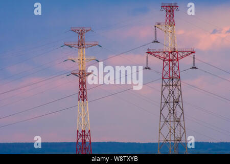 Kiew, Ukraine - August 08, 2019: Elektrische Stromleitungen bei Sonnenuntergang. Hochspannungsmasten in einer Reihe Stockfoto