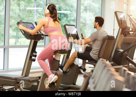 Zurück Porträt der jungen Frau das Tragen von Kopfhörern das Trainieren im Fitnessstudio anzeigen, kopieren Raum Stockfoto