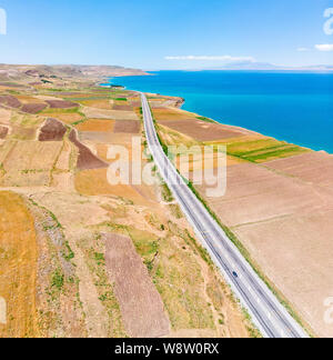 Luftaufnahme des Vansees, in der Türkei. Felder und Klippen mit Blick auf das kristallklare Wasser der größte See der Türkei. Straßen entlang der See Stockfoto