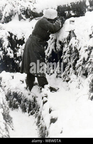 Deutscher Soldat feuert seine Waffe in dem harten Winter 1941/42 an der russischen Front Stockfoto