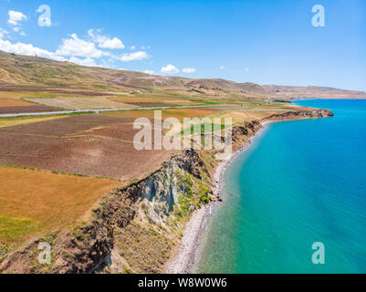 Luftaufnahme des Vansees, in der Türkei. Felder und Klippen mit Blick auf das kristallklare Wasser der größte See der Türkei. Straßen entlang der See Stockfoto