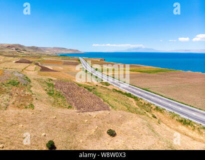 Luftaufnahme des Vansees, in der Türkei. Felder und Klippen mit Blick auf das kristallklare Wasser der größte See der Türkei. Straßen entlang der See Stockfoto