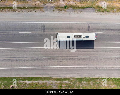 Luftaufnahme von einem Bus auf einer Straße mit zwei Fahrspuren in jede Richtung. Bus mit dem weißen Dach. Transport von Menschen, reisen, urlaub. Türkei Stockfoto