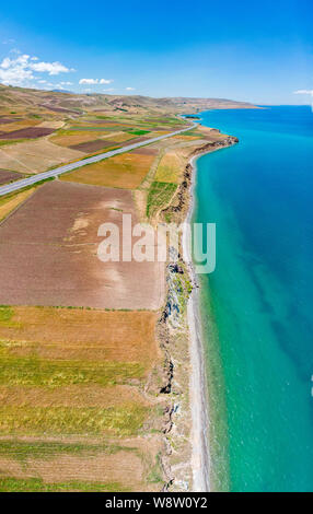 Luftaufnahme des Vansees, in der Türkei. Felder und Klippen mit Blick auf das kristallklare Wasser der größte See der Türkei. Straßen entlang der See Stockfoto