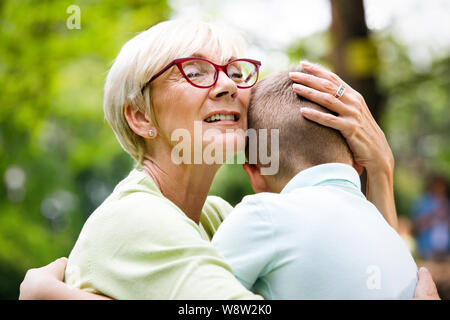 Glückliche Oma mit Enkel, die in einem Park im Freien Stockfoto