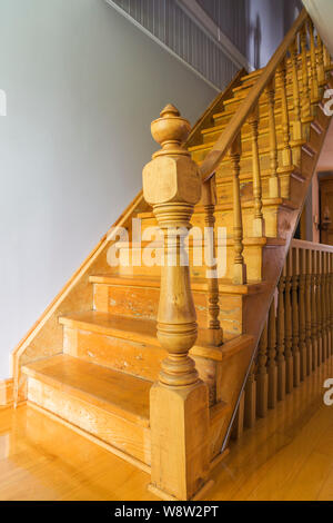 Pfosten und Treppen aus Kiefernholz führen in die obere Etage in ein altes Feldsteinhaus im Landhausstil aus den 1820 Jahren. Stockfoto