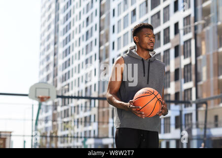 Taille bis Portrait von männlichen afrikanischen Mann mit Basketball Ball in Hof im freien Platz kopieren Stockfoto