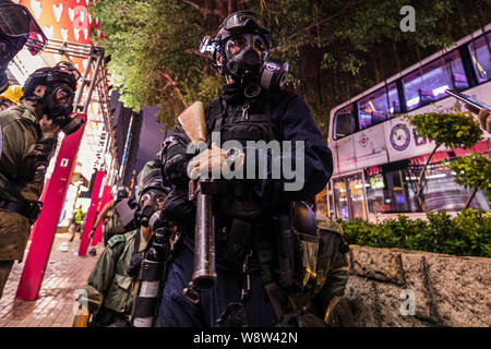 Ein Polizist steht auf der Hut während der Demonstration. die Woche Nummer 10 der Proteste in Hongkong zunächst vor der Auslieferung Rechnung, aber drehte sich in mehr Anfragen über pro-Demokratie in der Region von China. Heute die Proteste und die Konflikte um das gesamte Gebiet mit viel Gewalt und Guerillataktiken von der Demonstranten und der Polizei. Stockfoto