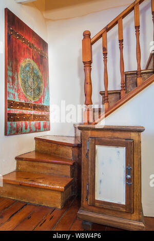 Die Kiefernholztreppe führt in die obere Etage in ein altes Feldsteinhaus im Landhausstil aus den 1820 Jahren. Stockfoto