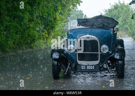 1929 Ford Roadster Fahrer bei schwerem Regen gefangen, Frome, Somerset UK Stockfoto