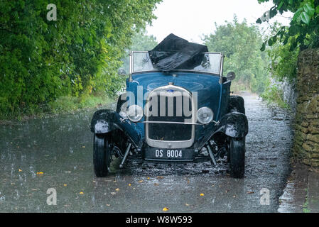 1929 Ford Roadster Fahrer bei schwerem Regen gefangen, Frome, Somerset UK Stockfoto