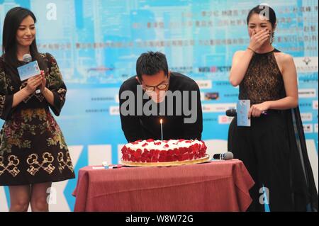Hong Kong Schauspieler Louis Koo, Mitte, bläst die Kerze sein Geburtstag neben chinesischen Schauspielerin Gao Yuanyuan zu feiern, Links, und Hong Kong Schauspielerin Miri Stockfoto