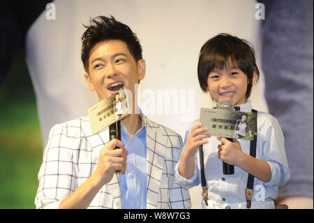 Taiwanesische Sänger und Schauspieler Jimmy Lin, Links, und sein Sohn Kimi Lächeln während einer Pressekonferenz für Jimmys Autobiografie in Peking, China, 27. Juni 2014. Stockfoto