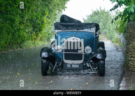 1929 Ford Roadster Fahrer bei schwerem Regen gefangen, Frome, Somerset UK Stockfoto