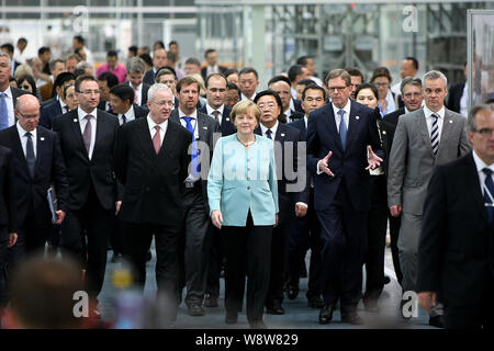 Die deutsche Bundeskanzlerin Angela Merkel, Mitte, wird begleitet von VW-Chef Martin Winterkorn, dritte Straße links, FAW Group Chairman Xu Jianyi, Dritte rechts, Dr Stockfoto