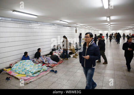 Ein Fahrgast Spaziergänge Vergangenheit Wanderarbeitnehmer Zusammenkunft in eine unterirdische Passage von der U-Bahnstation Chaoyangmen nachdem Sie versäumt, ihre Gehälter zu erhalten Stockfoto