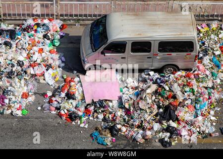 Ein minivan wird durch Berge von Müll auf der Straße in der bezirksfreien Stadt umgeben, Shenzhen, die südchinesische Provinz Guangdong, 20. November 2014. China Stockfoto