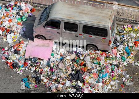 Ein minivan wird durch Berge von Müll auf der Straße in der bezirksfreien Stadt umgeben, Shenzhen, die südchinesische Provinz Guangdong, 20. November 2014. China Stockfoto