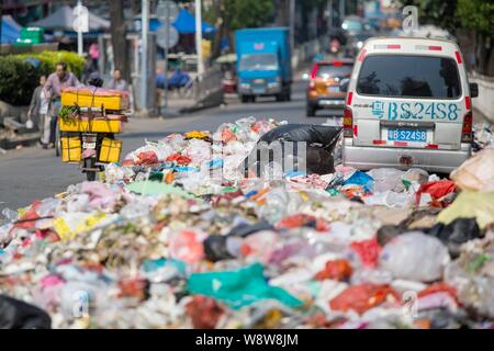 Ein minivan wird durch Berge von Müll auf der Straße in der bezirksfreien Stadt umgeben, Shenzhen, die südchinesische Provinz Guangdong, 20. November 2014. China Stockfoto