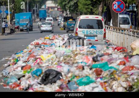 Ein minivan wird durch Berge von Müll auf der Straße in der bezirksfreien Stadt umgeben, Shenzhen, die südchinesische Provinz Guangdong, 20. November 2014. China Stockfoto