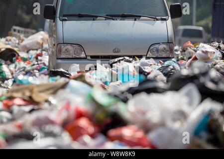 Ein minivan wird durch Berge von Müll auf der Straße in der bezirksfreien Stadt umgeben, Shenzhen, die südchinesische Provinz Guangdong, 20. November 2014. China Stockfoto