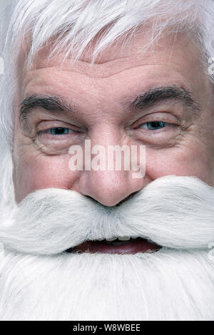 Nahaufnahme des Gesichts des Santa Claus. Weißhaariger alter Mann mit weißem Bart und Schnurrbart suchen in der Kamera. Stockfoto