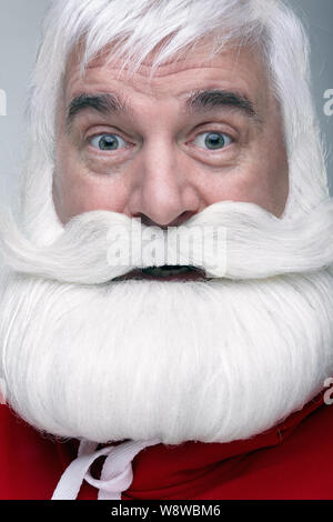 Nahaufnahme des Gesichts des Santa Claus. Weißhaariger alter Mann mit weißem Bart und Schnurrbart suchen in der Kamera. Stockfoto