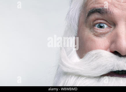 Nahaufnahme des Gesichts des Santa Claus. Weißhaariger alter Mann mit weißem Bart und Schnurrbart suchen in der Kamera. Stockfoto
