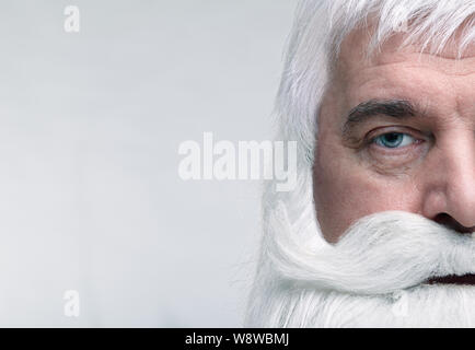 Nahaufnahme des Gesichts des Santa Claus. Weißhaariger alter Mann mit weißem Bart und Schnurrbart suchen in der Kamera. Stockfoto