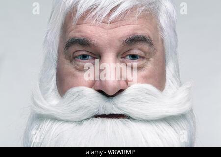 Nahaufnahme des Gesichts des Santa Claus. Weißhaariger alter Mann mit weißem Bart und Schnurrbart suchen in der Kamera. Stockfoto