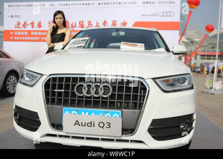 ---- Ein Modell stellt mit einem Audi Q3 Auto bei einem Automobil Ausstellung in Qingdao Stadt, East China Provinz Shandong, 15. März 2014. Volkswa Stockfoto