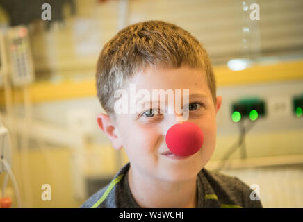 Wiesbaden, Deutschland. 27 Juni, 2019. Felix (10) Trägt ein Clown Nase in seinem sickroom. Der Verein "die Clown Doktoren e.V. ist ein Verband für professionelle Clowns in Krankenhäusern und Pflegeheimen arbeiten bundesweit. Die Akteure versuchen, die betroffenen Menschen Hoffnung zu geben und den Mut, wieder zu Leben durch Humor. Die Clown Doktoren sind auch aktiv in der Kinderklinik der Dr.-Horst-Schmidt-Kliniken. Credit: Andreas Arnold/dpa/Alamy leben Nachrichten Stockfoto