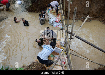 Rettungskräfte tragen Sandsäcke in schlammigen Wasser der Verletzung in Chengdu City zu blockieren, der Südwesten Chinas Provinz Sichuan, 9. Juli 2014. Rettungskräfte Stockfoto