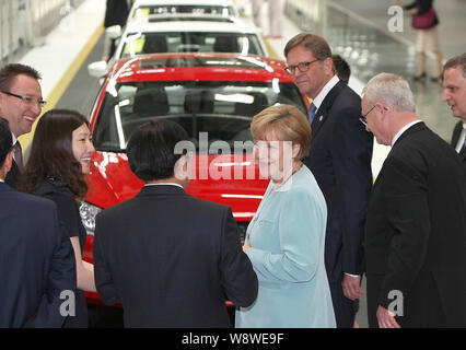 Die deutsche Bundeskanzlerin Angela Merkel, Mitte, hört sich die FAW-Gruppe Vorsitzender Xu Jianyi, dritte Straße links, neben Volkswagen CEO Martin Winterkorn, zweite rechts, Stockfoto