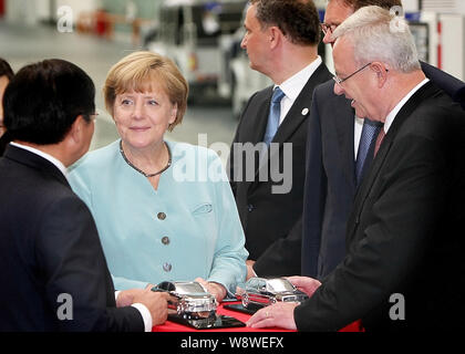 Die deutsche Kanzlerin Angela Merkel, die zweite links, hört sich die FAW-Gruppe Vorsitzender Xu Jianyi, links, neben Volkswagen CEO Martin Winterkorn, rechts, wie Sie Stockfoto