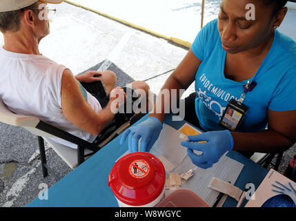 Orlando, USA. 11 Aug, 2019. Karen McKenzie von Orange County, Florida Gesundheit Abteilung bereitet die Hepatitis-A-Impfstoff zu Nelson Fitzpatrick an einem Hepatitis-A-Impfung Ereignis in Reaktion auf die Hepatitis in Florida gehalten wird ein Ausbruch und dem 1. August 2019 Erklärung der öffentlichen Gesundheit in den Staat zu verwalten. Juli 1, 2019, siebenundzwanzig Mitgliedstaaten haben erfahrene Ausbrüche der Krankheit, mit Florida in 2,586 gemeldeten Fälle, die Dritthöchste in den Vereinigten Staaten, in 31 Todesfälle. Credit: SOPA Images Limited/Alamy leben Nachrichten Stockfoto