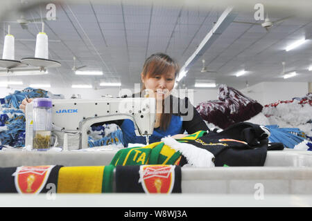 Ein weiblicher chinesischer Arbeiter näht einen Fan-schal für die Brasilien Wm 2014 im verarbeitenden Fabrik in LinAn Stadt produziert, East China Zhejiang provinc Stockfoto