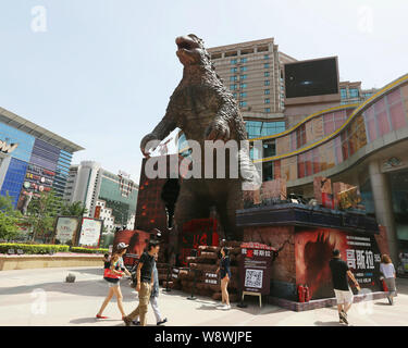 ---- Fußgänger Spaziergang, vorbei an einem riesigen Modell der Godzilla vor einem Einkaufszentrum in Peking, China, 25. Mai 2014. Die neueste Version von Monster fl Stockfoto