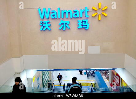 ------ Chinesische Kunden nehmen Rolltreppen in einem Supermarkt von Walmart in Shanghai, China, 25. November 2014. Wal-Mart Stores Inc. werden 250 Arbeitsplätze cut i Stockfoto