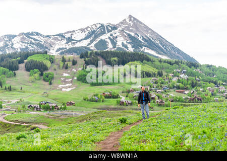 Menschen wandern auf Snodgrass Trail mit Blick auf den Mount Crested Butte, Colorado Peak und Ski Village im Sommer Stockfoto