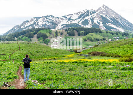 Mann stand unter Bild auf Snodgrass Trail mit Kamera und bokeh Hintergrund Blick auf Mount Crested Butte, Colorado peak Stockfoto