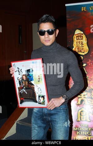 Hong Kong Sänger und Schauspieler Aaron Kwok wirft mit Karikaturen während einer Sitzung für chinesische Filme in Hong Kong, China, 22. Januar 2014. Stockfoto