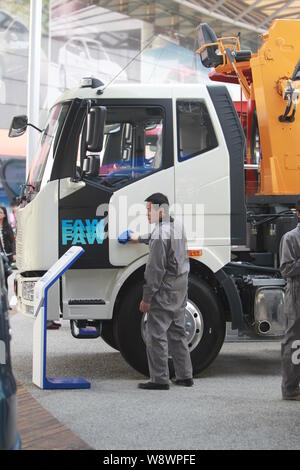 ---- Ein chinesischer Arbeiter Stäube aus einem Lkw von FAW im 15. Shanghai Internationalen Automobil- Ausstellung, die Auto Shanghai 2013 bekannt, Stockfoto