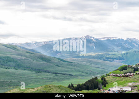 Mount Crested Butte, USA - Juni 21, 2019: Colorado alpine Wiesen und Häuser auf Snodgrass Wanderweg im Sommer an bewölkten Tag mit grünem Gras und Mo Stockfoto