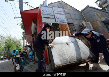 ------ Chinesische Offiziere von der Beijing Municipal Bureau der Stadt Verwaltung und Rechtsdurchsetzung ein Grill Konfiszieren an einem strassenrand Grill Restaurant Stockfoto