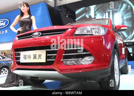 ---- Ein Modell stellt mit einem Ford Kuga bei einem Auto Show in Zhengzhou City, Central China Provinz Henan, 11. April 2013. Ford Motor Co. und die Ch Stockfoto