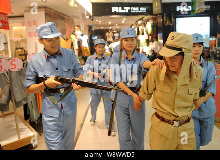 Chinesische Beamte in blauen Uniformen des 8. Route Armee escort ein Mitarbeiter in einer Uniform der japanischen Armee während des Zweiten Weltkriegs bekleidet gekleidet, Stockfoto