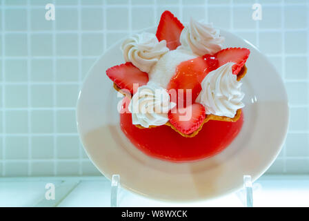 Eine Probe von Vanilleeis mit Erdbeeren und Peitsche auf einem weissen Teller, Japan Stockfoto