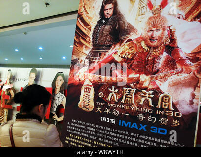 ---- Eine Chinesische filmgoer betrachtet ein Plakat des Films, der Affe König, in einem Kino in Kunshan City, Central China Provinz Hubei, 3. Februar 201 Stockfoto